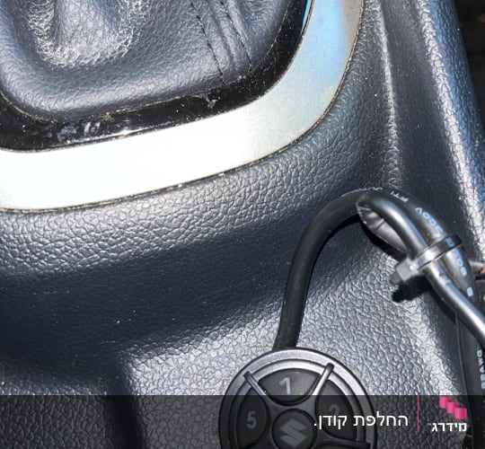 כפתור עגול עם מספרים ליד ידית הילוכים ברכב